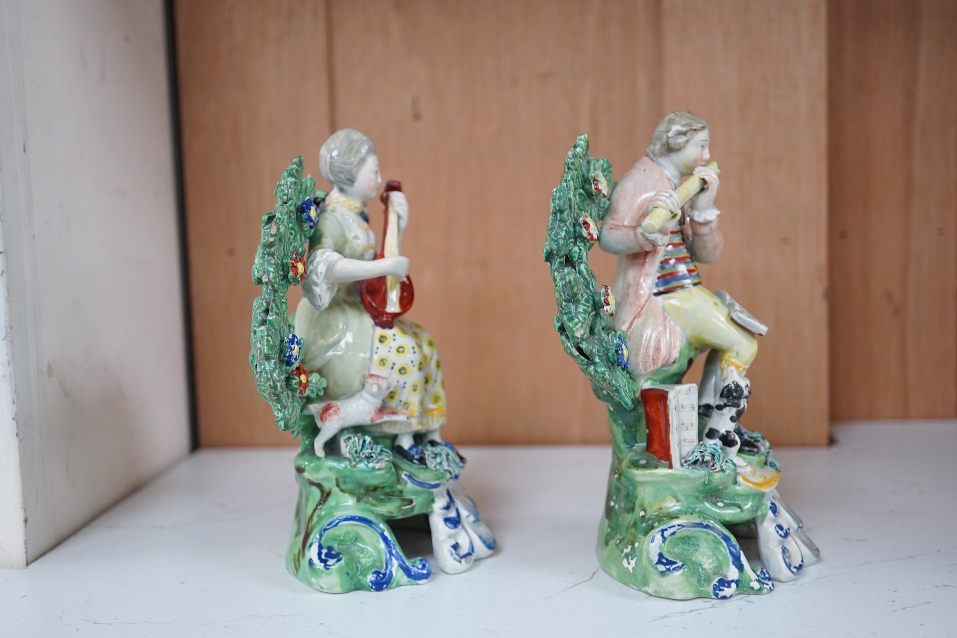 A pair of early 19th century pearlware groups of seated musicians with dogs, 15.5 cm high, Condition - minor faults otherwise fairly good, provenance - sold by Jonathan Horne Antiques